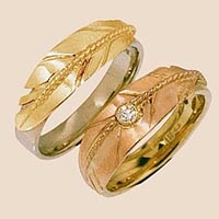 Bicolor gouden arendsveer-trouwringen van edelsmid Zhaawano