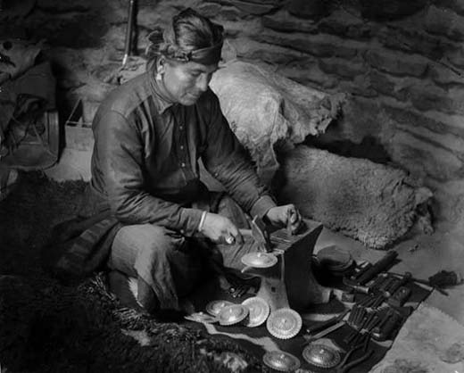 Een Dineh-smid smeedt zilveren concha's in zijn studio, ca. 1900